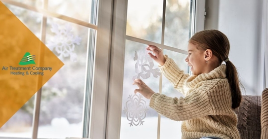 child placing snowflake crafts on windows
