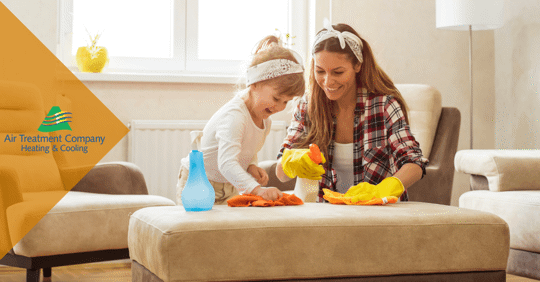 mother and daughter cleaning living room