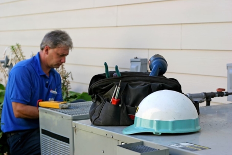 Repairman working on an outdoor unit