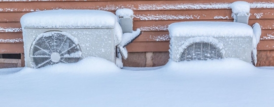 two heat pumps buried in snow